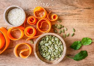 Pumpkin seeds and sesame seeds in bowls.