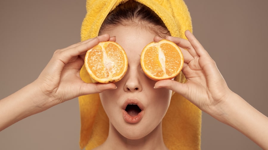 Woman holding sliced orange.